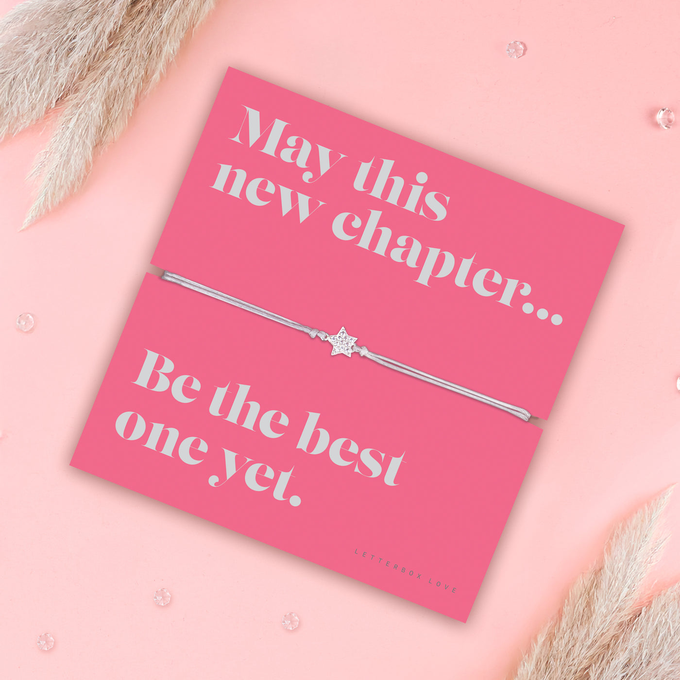 Friendship bracelet with a silver star charm on an adjustable cord, displayed on a pink card reading “May this new chapter… be the best one yet” — an uplifting bracelet for a friend and thoughtful friendship gift by Letterbox Love.