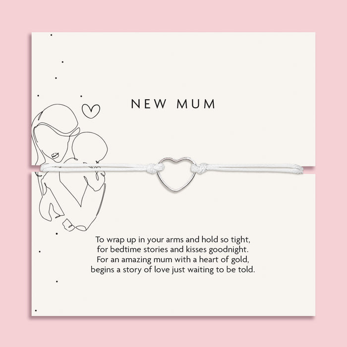 An elegant 'New Mum' bracelet with a dainty heart charm, displayed on a pastel pink background adorned with baby's breath flowers and sparkling crystals, symbolizing the gentle embrace of motherhood.