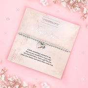 A silver beaded bracelet with a heart and flower charm displayed on a card reading "To my Lovely Niece" from Letterbox Love, set against a soft pink background with eucalyptus leaves and small crystals. The card includes a heartfelt poem, making it a perfect sentimental gift for a niece.