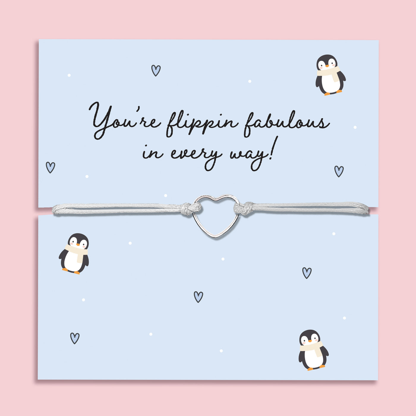 Flippin’ Fabulous Penguin Bracelet displayed on a light blue festive card decorated with cartoon penguins, tiny hearts, and falling snow dots. The bracelet features a silver-tone open heart charm on a grey adjustable cord, making it a fun and meaningful Christmas jewellery gift. Perfect as a Secret Santa present, stocking filler, or festive gift for penguin and animal lovers. 