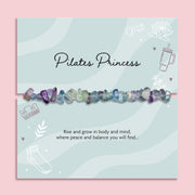 Natural Fluorite crystal chip bracelet displayed on Pilates Princess gift card, elasticated healing crystal bracelet in purple, green and blue tones, wellness jewellery gift for yoga lover or Pilates enthusiast.