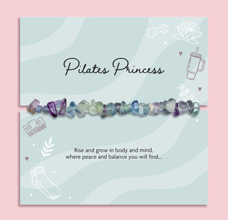 Natural Fluorite crystal chip bracelet displayed on Pilates Princess gift card, elasticated healing crystal bracelet in purple, green and blue tones, wellness jewellery gift for yoga lover or Pilates enthusiast.