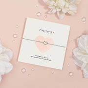 Elegant silver heart-shaped necklace on a 'POSITIVITY' card with the message 'A little gift just for you, some positivity to see you through.