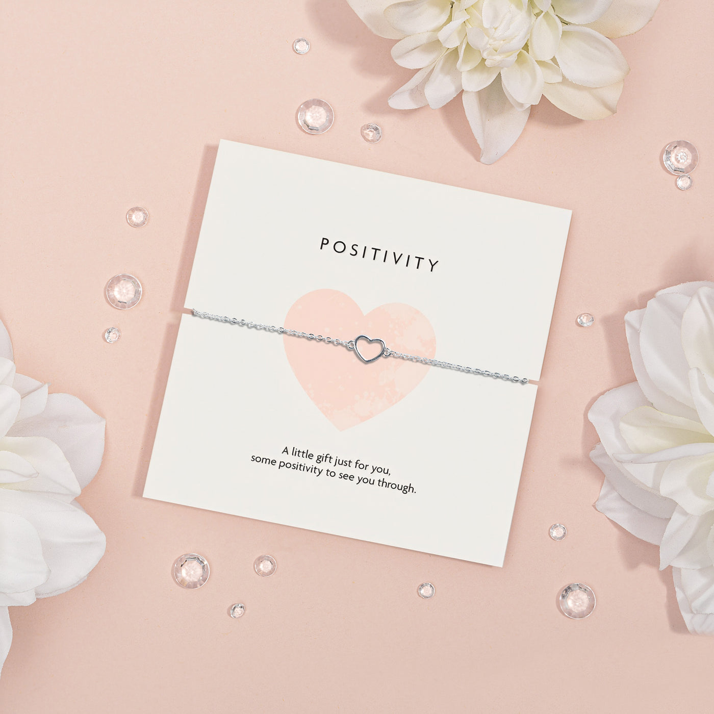 Elegant silver heart-shaped necklace on a 'POSITIVITY' card with the message 'A little gift just for you, some positivity to see you through.