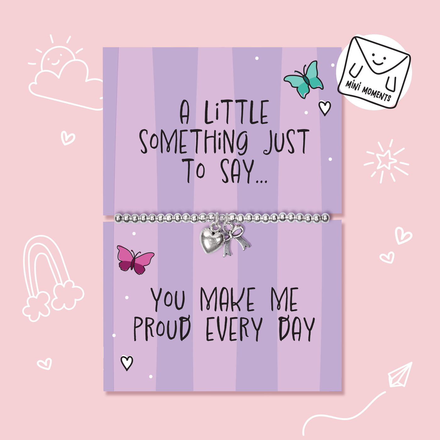 A silver beaded bracelet with a heart charm and bow pendant displayed on a lavender card that reads 'A LITTLE SOMETHING JUST TO SAY.