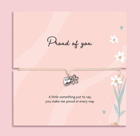 Proud of you bracelet with heart and flower charm on adjustable cord, displayed on pink sentiment card with message, encouragement gift