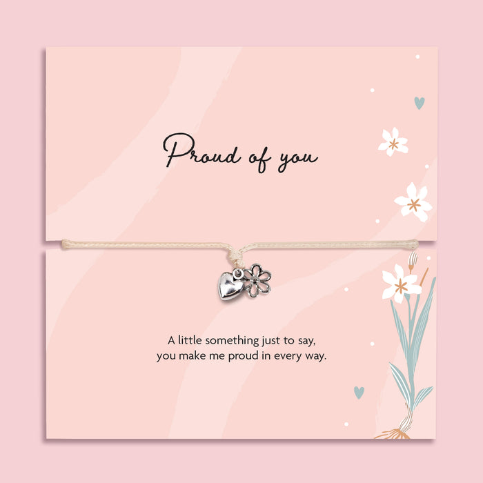 Proud of you bracelet with heart and flower charm on adjustable cord, displayed on pink sentiment card with message, encouragement gift