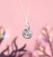 Silver pumpkin-shaped charm bracelet on a pink background, a cute charm bracelet for Autumn and Halloween