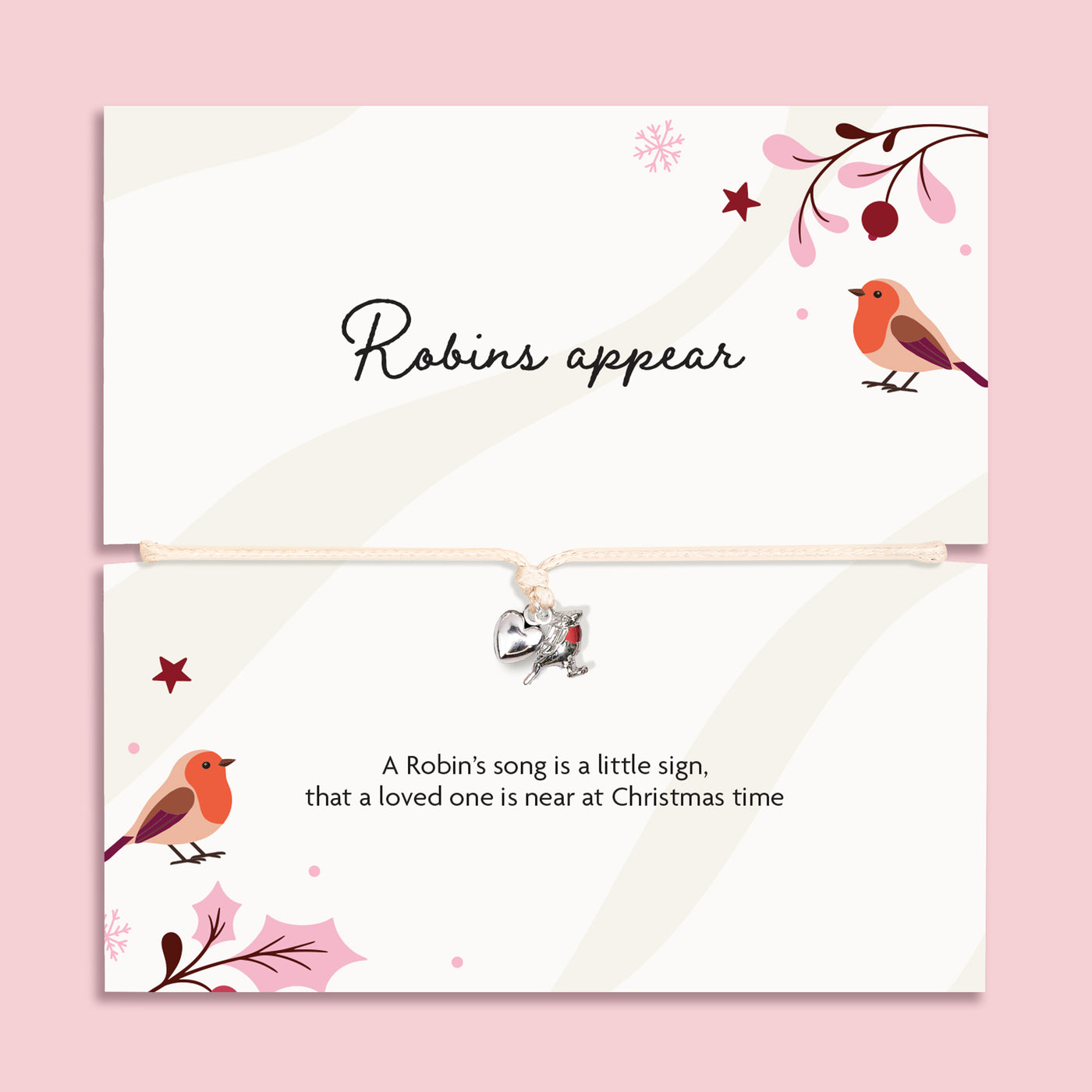 A Christmas bracelet set featuring a top card with the script text 'Robins appear' to bring comfort in the festive season. The bracelet is adjustable with a small silver robin charm on a cream cord, set against a solid pink background.