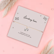 Card with 'Sending love' text and a heart charm on a pink background