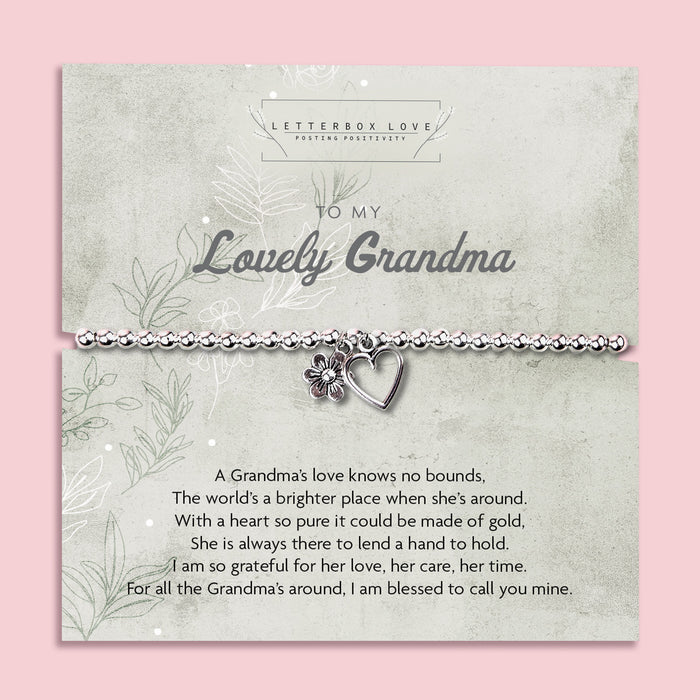 A silver beaded bracelet with a heart and flower charm displayed on a card reading "To my Lovely Grandma" from Letterbox Love, set against a soft pink background. The card includes a heartfelt poem, making it a perfect sentimental gift for a grandma.