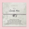 A silver beaded bracelet with a heart and flower charm displayed on a card reading 