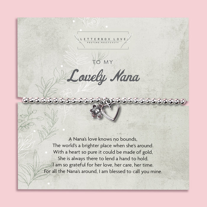 A silver beaded bracelet with a heart and flower charm displayed on a card reading "To my Lovely Nana" from Letterbox Love, set against a soft pink background. The card includes a heartfelt poem, making it a perfect sentimental gift for a Nana.