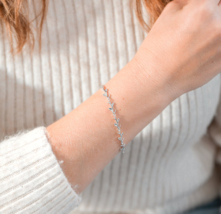 silver-plated vine bracelet on a woman's arm with a neutral background