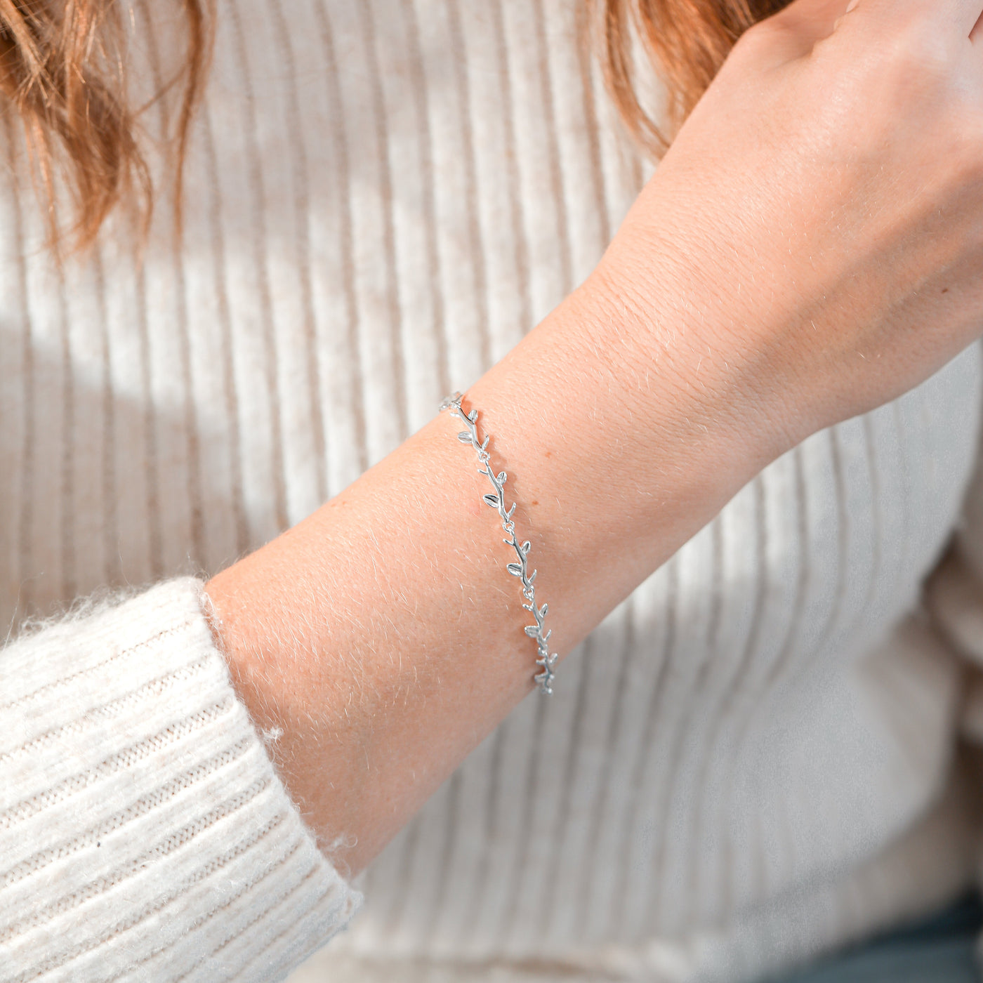 silver-plated vine bracelet on a woman's arm with a neutral background