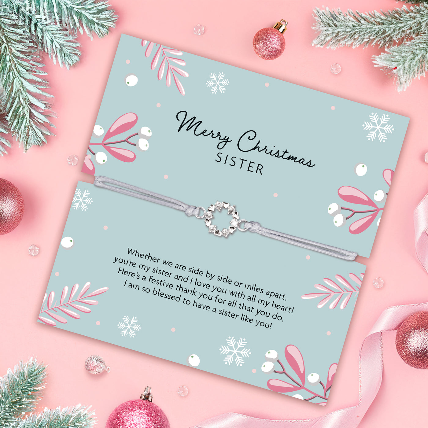 Christmas poem card for a sister with decorative elements on a pink background. The bracelet is a circular cubic zirconia wreath, friendship bracelet for a sister.