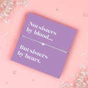 Mounted on a vibrant card with the heartfelt message: "Not sisters by blood… but sisters by heart," this bracelet is the perfect keepsake to show your appreciation for someone who means the world to you.