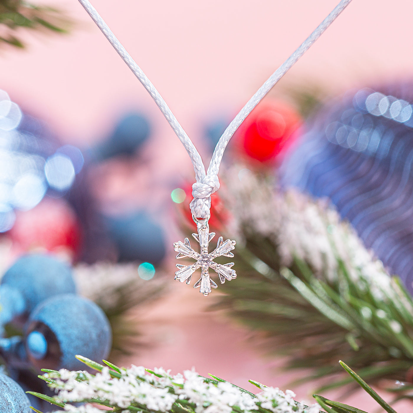 A festive background with a detailed photo of a snowflake bracelet charm
