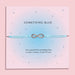 Something Blue wedding bracelet with silver-plated star charm and cubic zirconia on pale blue cord, displayed on a pink poem card.