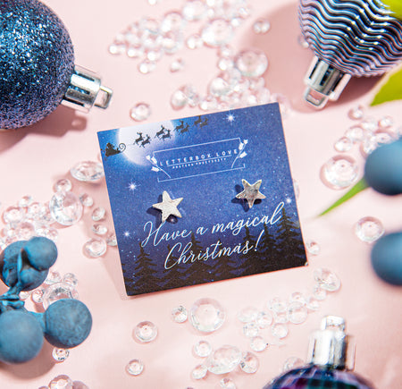 A pair of star-shaped earrings presented on a 'Letterbox Love' card with a festive night sky design and the message 'Have a magical Christmas!'