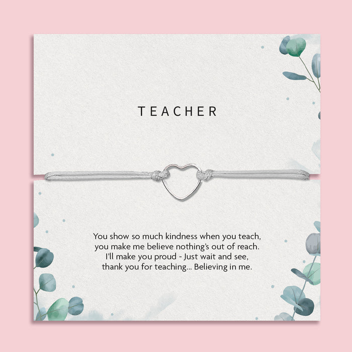 A thoughtful gift card titled "TEACHER" featuring a heartfelt appreciation note for a teacher, accompanied by a simple yet elegant bracelet with a heart-shaped charm. The card's design includes subtle green foliage patterns on a soft grey background, creating a calm and appreciative atmosphere suitable for expressing gratitude to educators.