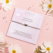 Pale pink "teaching assistant" thank you care with a subtle grey friendship bracelet with a cute butterfly charm. A beautiful gift to say thank you to a teacher under £10