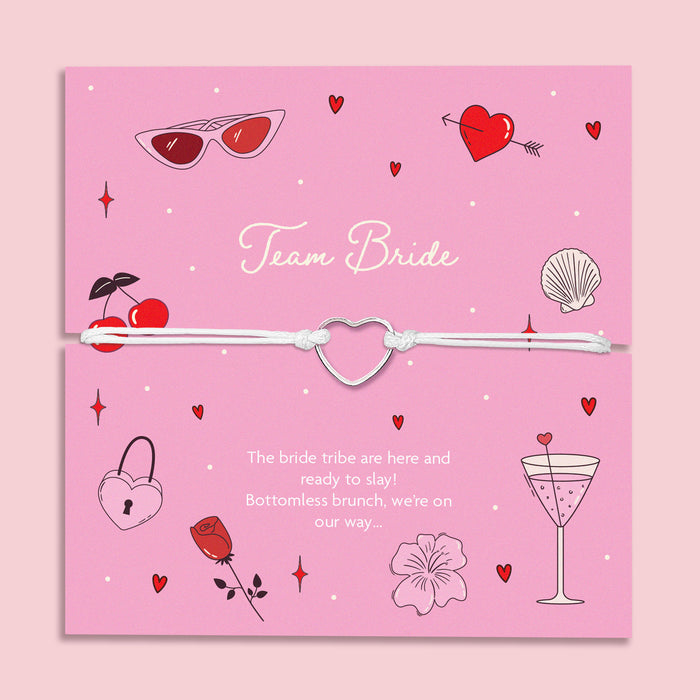 Team Bride hen party bracelet – cute silver heart charm on white cord, displayed on a fun pink card with cocktail, cherry, and love heart designs. Perfect for bridesmaid proposal boxes, hen do favours, bride tribe accessories, or bottomless brunch party gifts. Affordable letterbox jewellery for bachelorette celebrations.