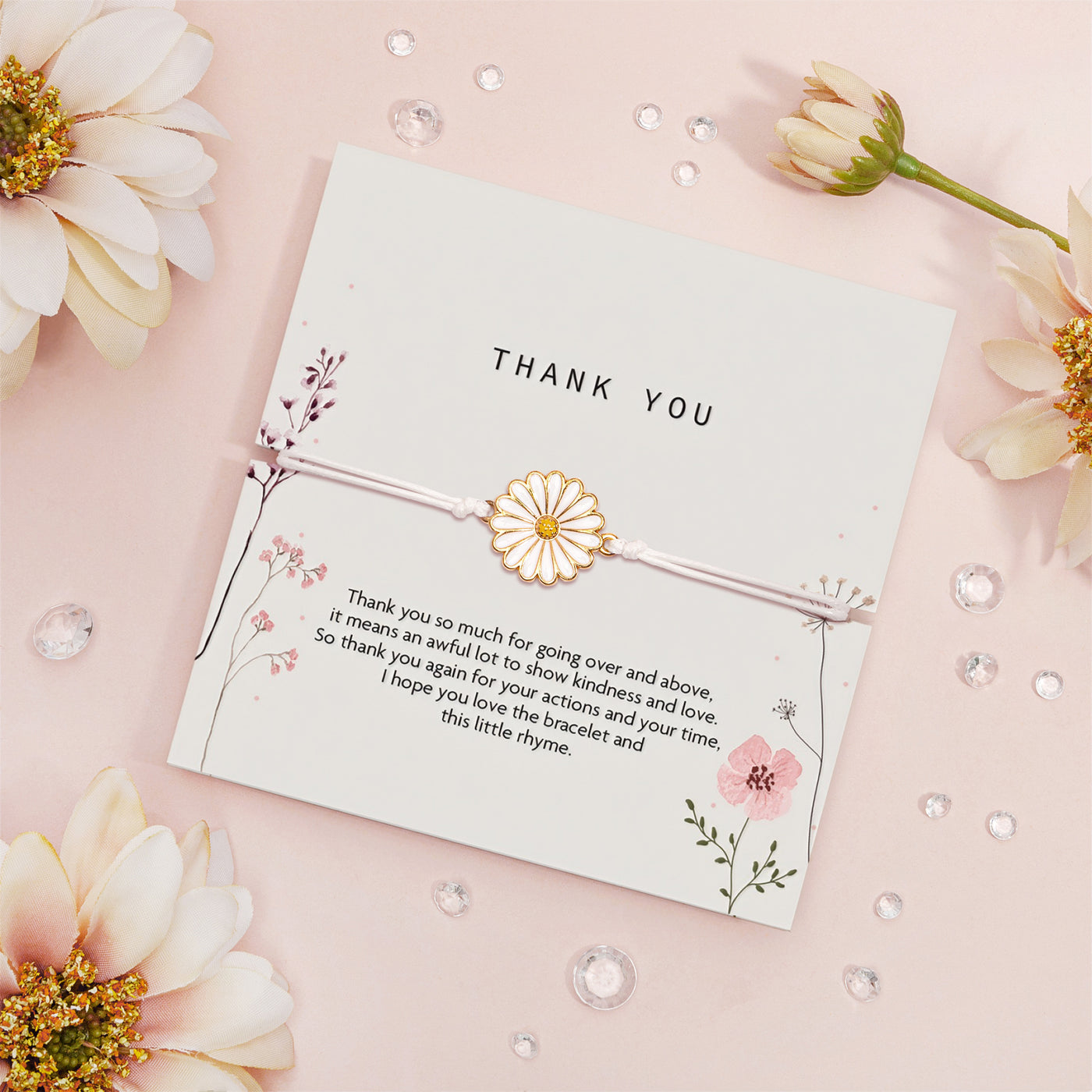 Elegant 'Thank You' card on a blush pink backdrop, adorned with a daisy-inspired bracelet. The card showcases delicate floral illustrations and a heartfelt gratitude message. 