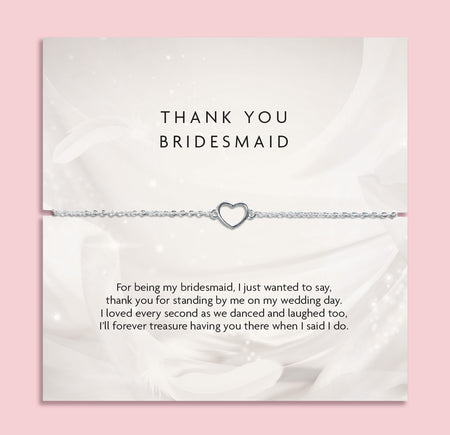 Silver bracelet with heart charm on a thank you card for a bridesmaid, on a pink background. A meaningful gift for a bridal party, silver jewellery to say thank you to a bridesmaid.