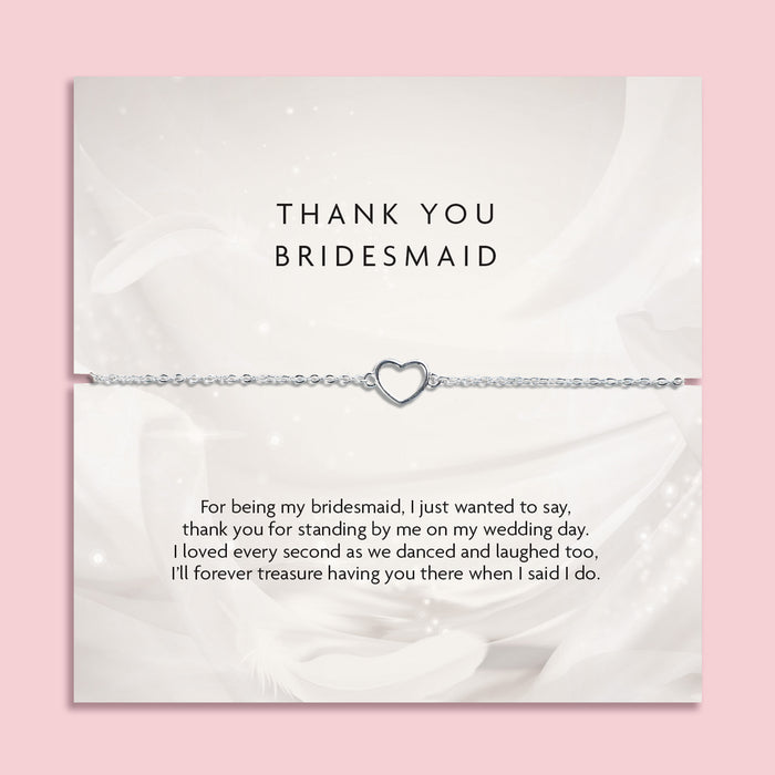Silver bracelet with heart charm on a thank you card for a bridesmaid, on a pink background. A meaningful gift for a bridal party, silver jewellery to say thank you to a bridesmaid.