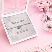 Silver beaded bracelet with heart and flower charms, presented in a white gift box alongside a card titled "Thank You Mum." The card features a heartfelt message expressing love, appreciation, and gratitude for everything a mother does.
