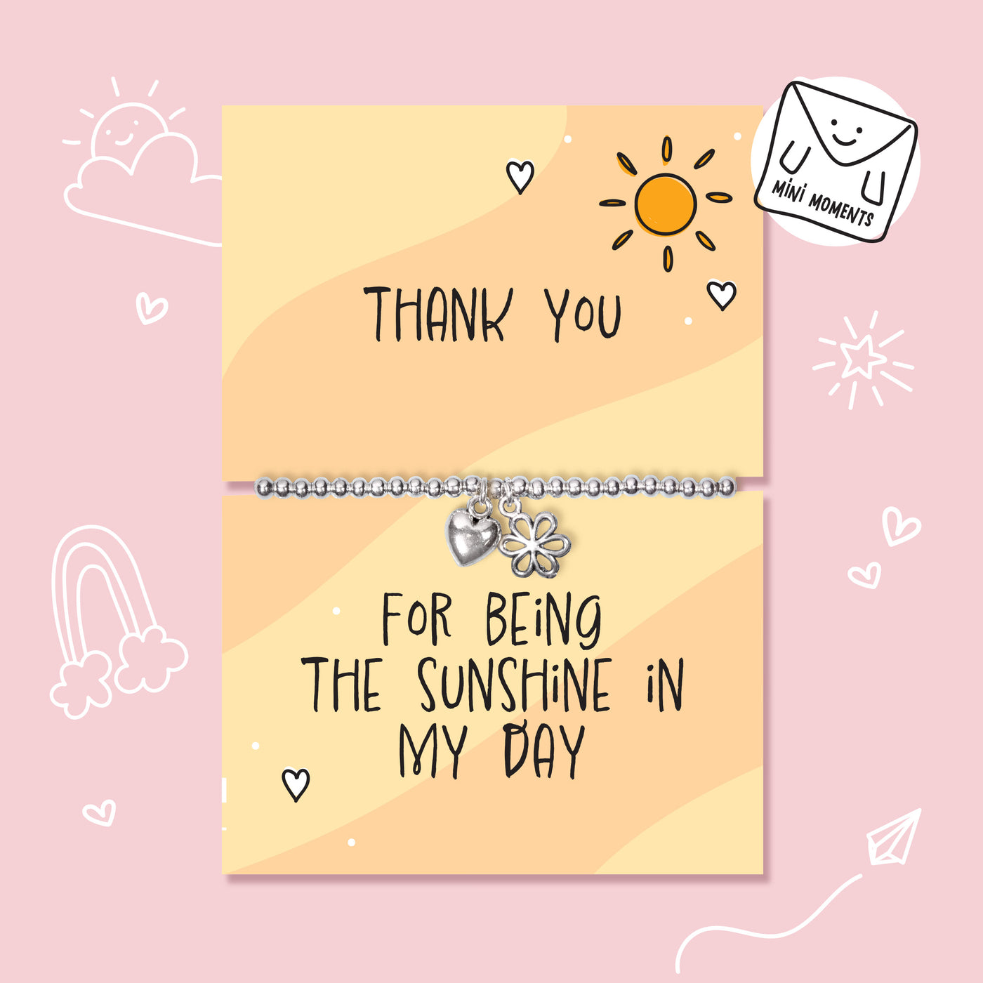 A silver beaded bracelet with a flower charm and a heart charm is displayed on a two-part yellow card that reads 'THANK YOU' and 'FOR BEING THE SUNSHINE IN MY DAY' on a pink background with cute doodles.