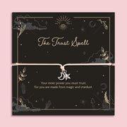 Moon and star charm bracelet on adjustable cord displayed on black celestial Trust Spell affirmation card with mystical symbols, spiritual jewellery gift.