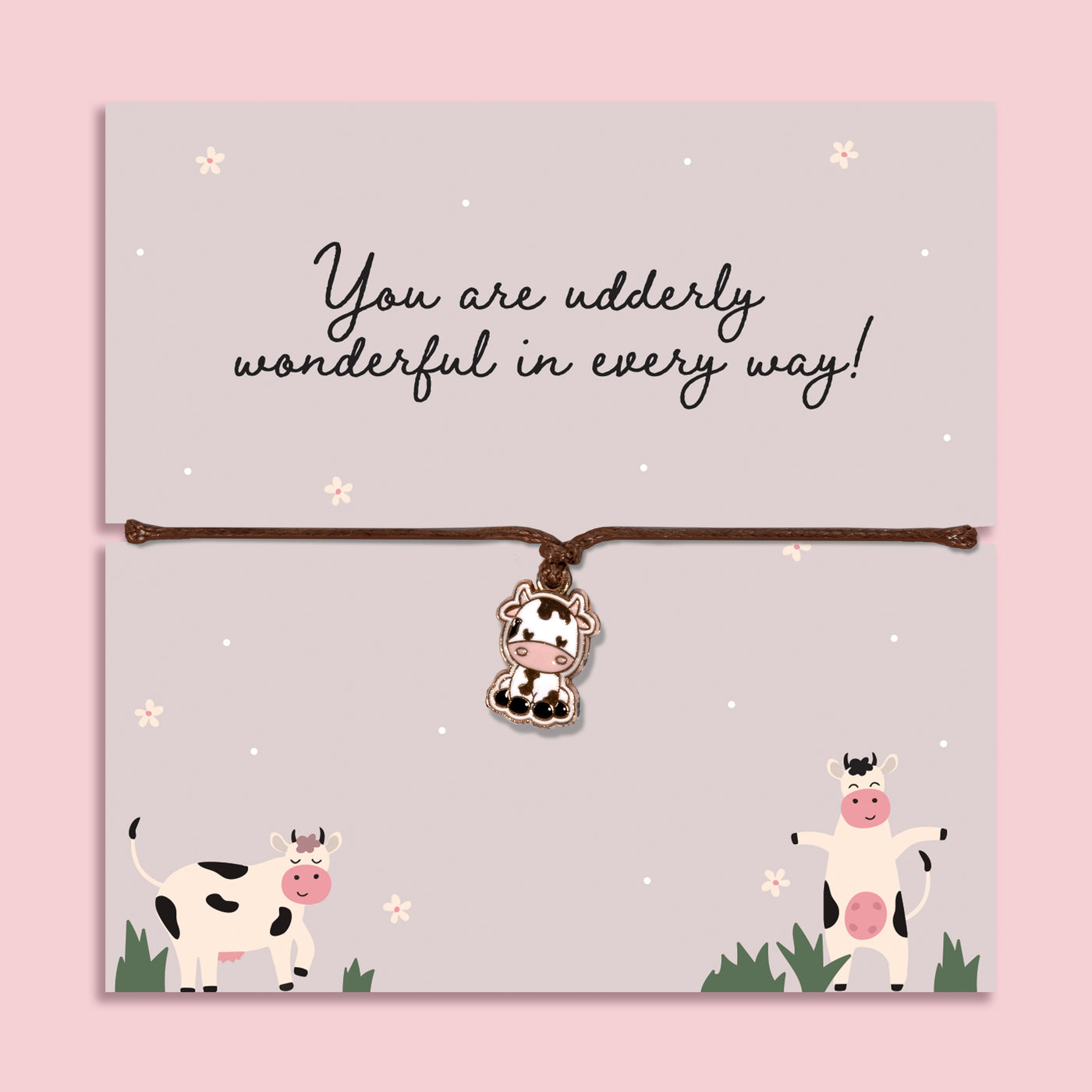 Adjustable cord bracelet with cute cow charm displayed on Udderly Wonderful message card, fun friendship jewellery gift with positive quote on pastel background.