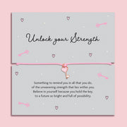 Pink bracelet with heart key charm on a motivational card with text on a pink background