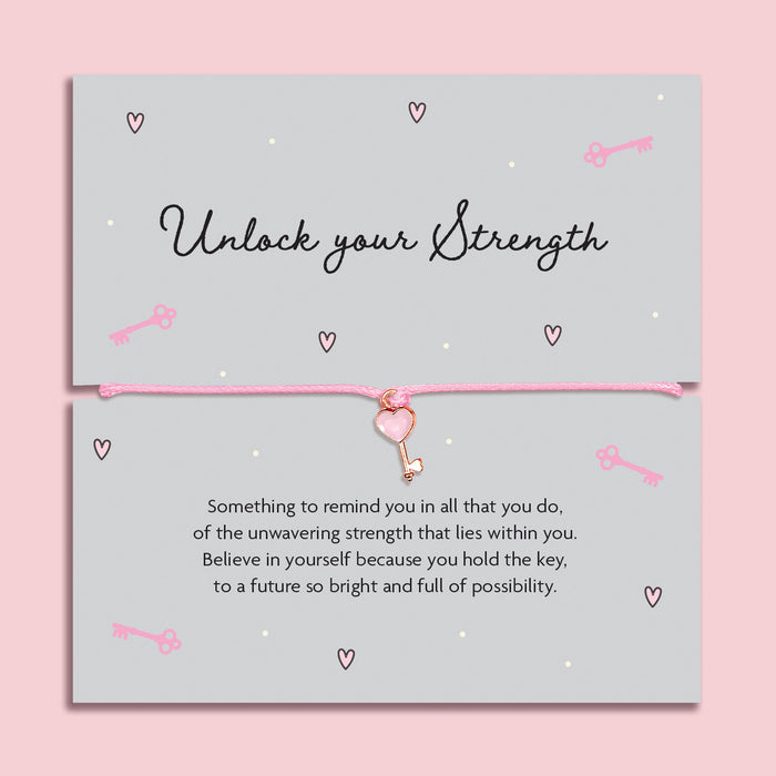 Pink bracelet with heart key charm on a motivational card with text on a pink background