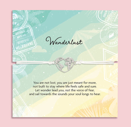 Adjustable white cord Wanderlust bracelet with a silver world map heart charm displayed on a travel-themed poem card and presented in a luxury white butterfly envelope.