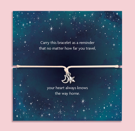 Moon and star bracelet featuring a silver-tone crescent moon and star charm on an adjustable cord, presented on a galaxy night sky card with the message “no matter how far you travel, your heart always knows the way home.” This celestial bracelet makes a meaningful travel gift, long distance friendship bracelet, or wanderlust jewellery keepsake. It’s a thoughtful gift for her, perfect for birthdays, farewells, graduations, or symbolic everyday wear.