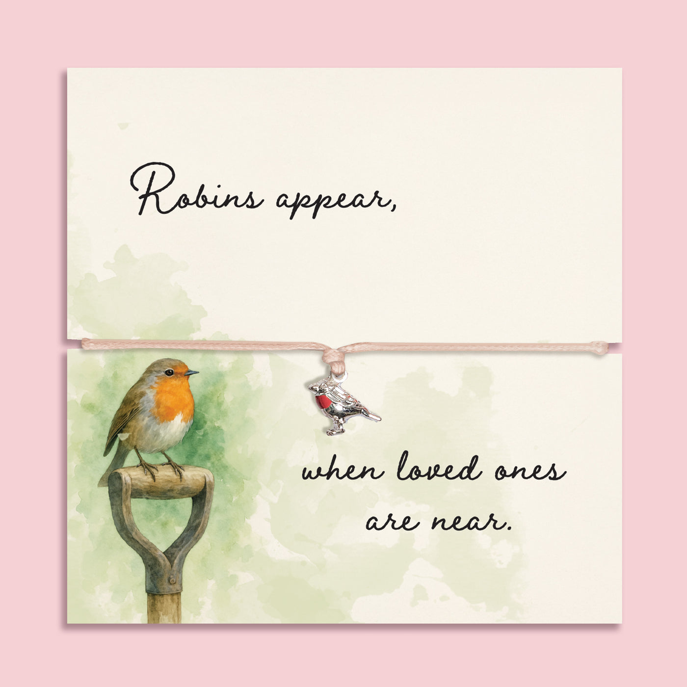Memorial bracelet with silver robin charm and pink cord, displayed on a sentimental card reading “Robins appear, when loved ones are near,” with soft green watercolour and robin illustration.