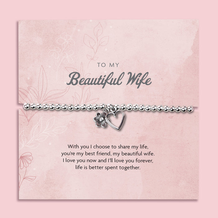 A silver-plated beaded bracelet with a heart and flower charm displayed in a premium keepsake box. The box includes a pink backing card with the message "To My Beautiful Wife" and a heartfelt poem. 