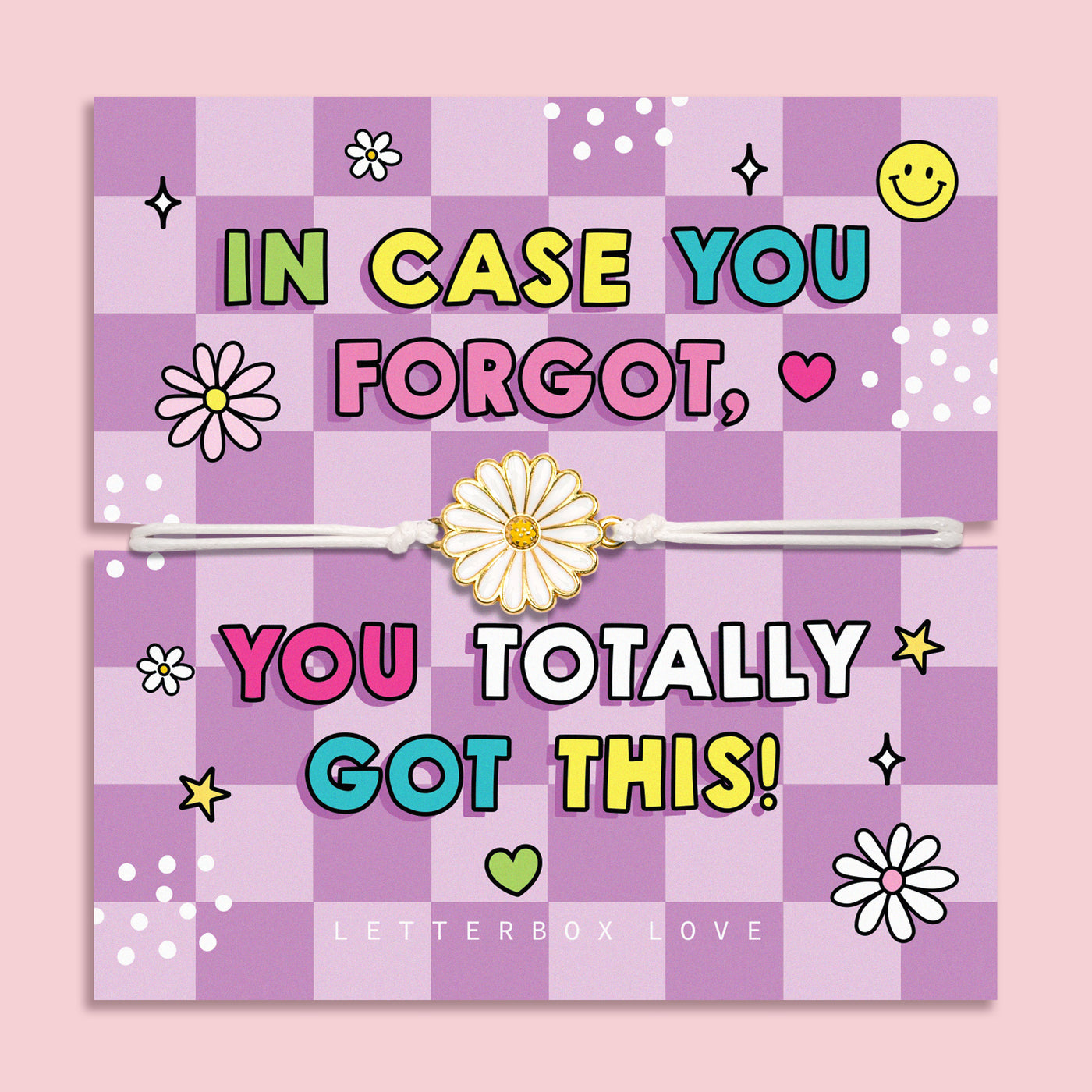A pastel pink and lavender checkered greeting card with colorful text reading 'IN CASE YOU FORGOT, YOU TOTALLY GOT THIS!' and a white elastic bracelet with a daisy charm laid across the center. The card is photographed against a soft pink background, with 'LETTERBOX LOVE' printed at the bottom.