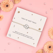 Silver-plated four-leaf clover charm bracelet on a "You’ve Got This!" motivational card with a pink background and daisies. Perfect for inspiring confidence, this charm bracelet makes a thoughtful gift for someone in need of a little encouragement, featuring positive affirmations for women, friends, and those facing challenges.