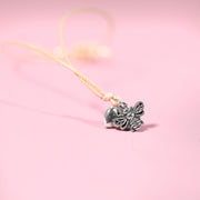 Silver bee-shaped pendant on a pink background