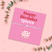 Happy Birthday Queen bracelet with star charm on adjustable cord displayed on pink birthday card with cake illustration, birthday gift for her