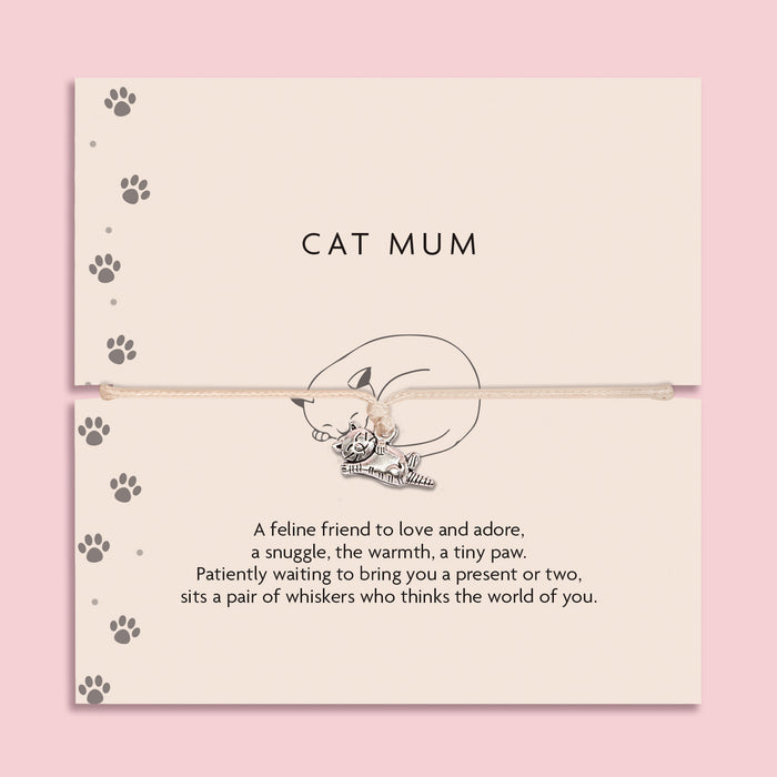 Cat-themed bracelet on a card with paw prints and text on a pink background