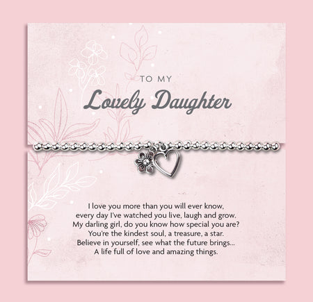 A silver beaded bracelet with a heart and flower charm displayed on a card reading 