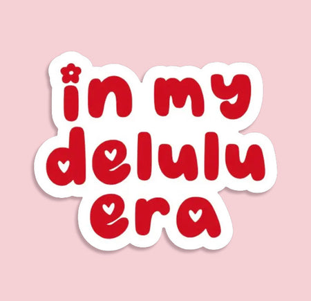 Red text 'in my delulu era' on a pink background. Cute aesthetic sticker for journals or water bottles.