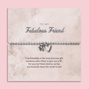 Silver beaded bracelet with heart and flower charms, displayed in a white gift box alongside a card titled "To My Fabulous Friend." The card features a heartfelt message about friendship, making this a perfect gift for a cherished friend.