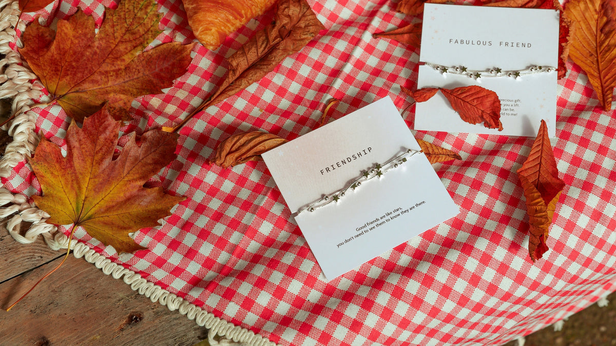 A summer scene with pink blanket, flowers and strawberries. Central is a Letterbox Love friendship bracelet with elegant friendship bracelet. A meaningful gift for a best friend.