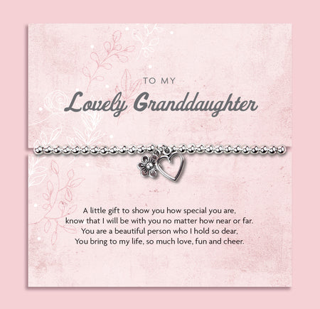 Silver beaded bracelet with heart and flower charms, presented in a white gift box alongside a card titled 